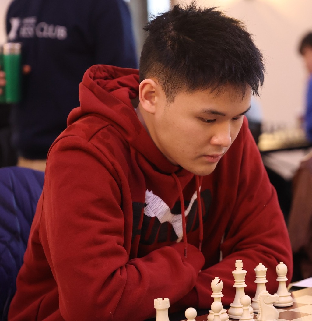 Awonder Liang at the board in a red hooded sweatshirt at the 2023 Ivy League Challenge in Toronto