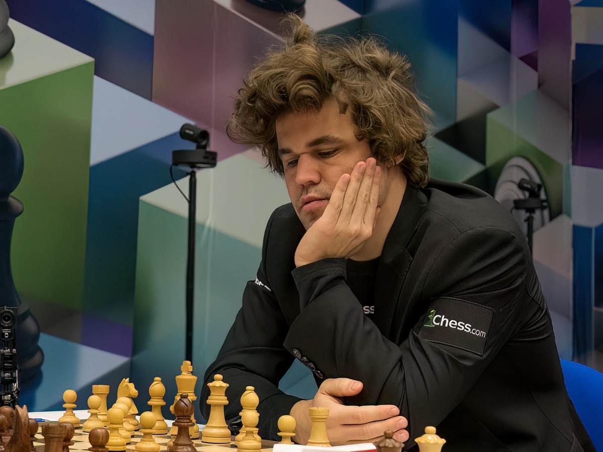 Magnus Carlsen at the board, chin in hand, at Tata Steel Chess 2023